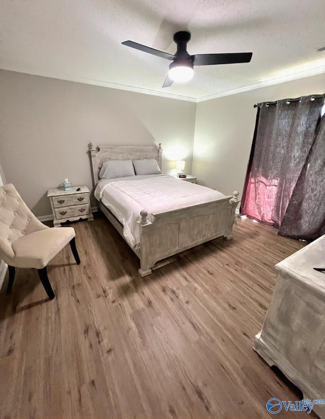 bedroom with ceiling fan, hardwood / wood-style flooring, ornamental molding, and a textured ceiling