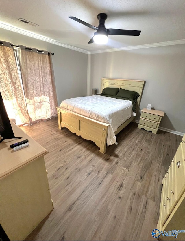 bedroom featuring ceiling fan, ornamental molding, and hardwood / wood-style floors