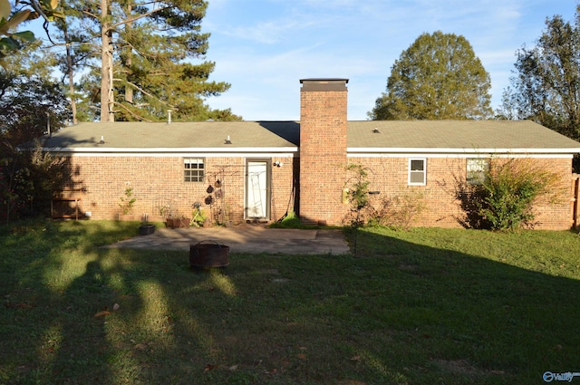 back of property with a yard and a patio area