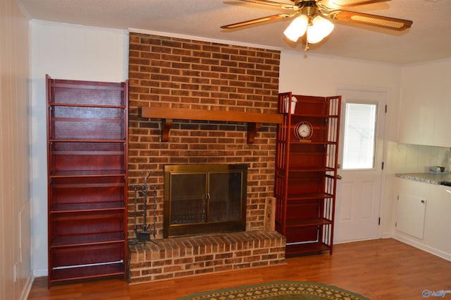 unfurnished living room featuring a fireplace, hardwood / wood-style floors, a textured ceiling, and ceiling fan