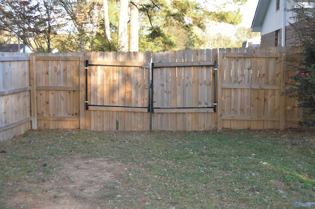 view of gate with a lawn