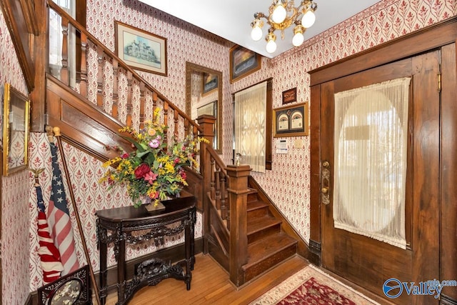 staircase featuring an inviting chandelier and hardwood / wood-style flooring