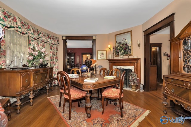 dining space featuring a fireplace and wood-type flooring