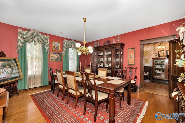 dining space featuring wood-type flooring and a chandelier