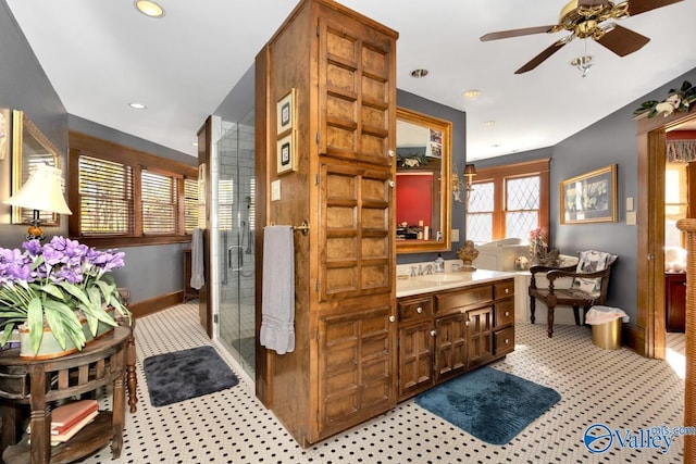 bathroom featuring a shower with door, vanity, and ceiling fan