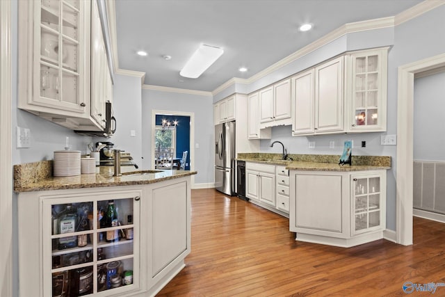 kitchen with light hardwood / wood-style flooring, white cabinets, stainless steel refrigerator with ice dispenser, and sink