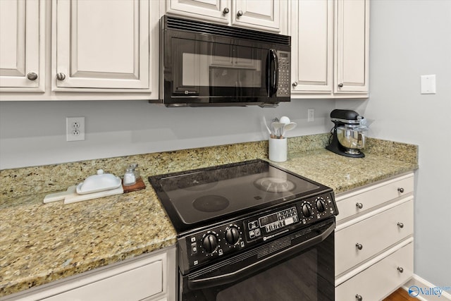 kitchen featuring black appliances, white cabinets, and light stone countertops