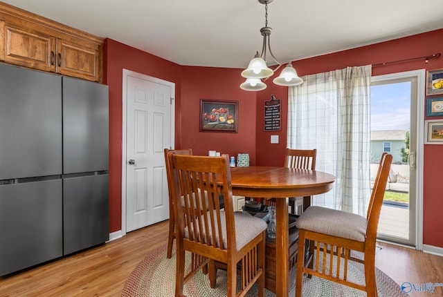 dining space with light wood finished floors and baseboards