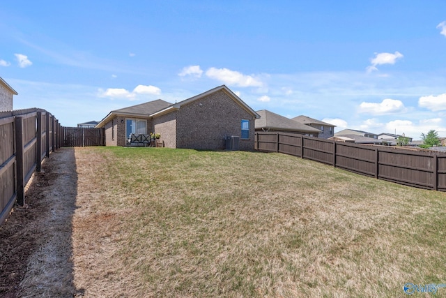 view of yard with central AC unit and a fenced backyard