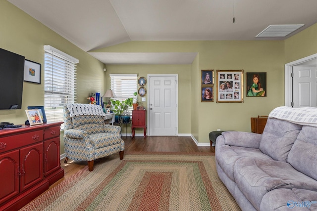 living area with visible vents, baseboards, vaulted ceiling, and wood finished floors