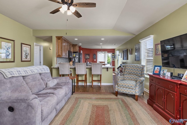 living area featuring baseboards, ceiling fan, light wood-style floors, recessed lighting, and lofted ceiling