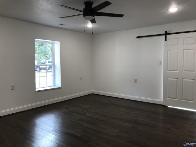 716 Ruby St, Gadsden, AL 35901 - spare room featuring ceiling fan, a barn door, and dark wood-style flooring