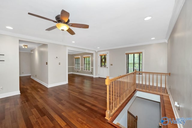 empty room with baseboards, ornamental molding, ceiling fan, and wood finished floors
