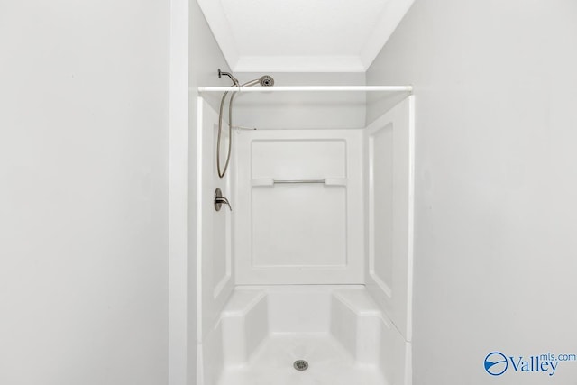 bathroom with a shower stall and ornamental molding