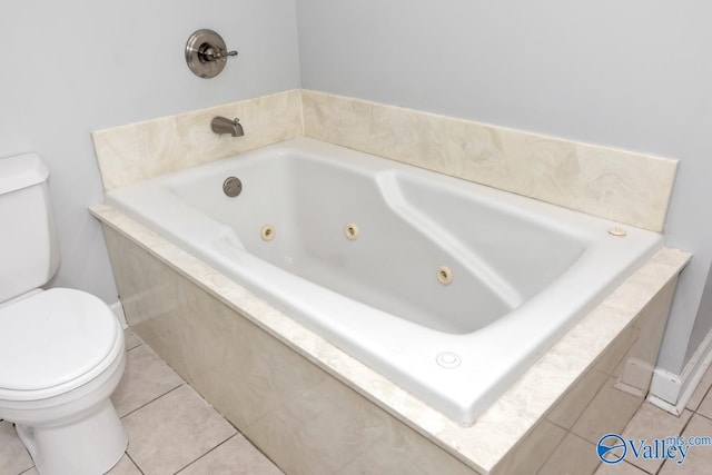 bathroom featuring toilet, tile patterned flooring, and a jetted tub