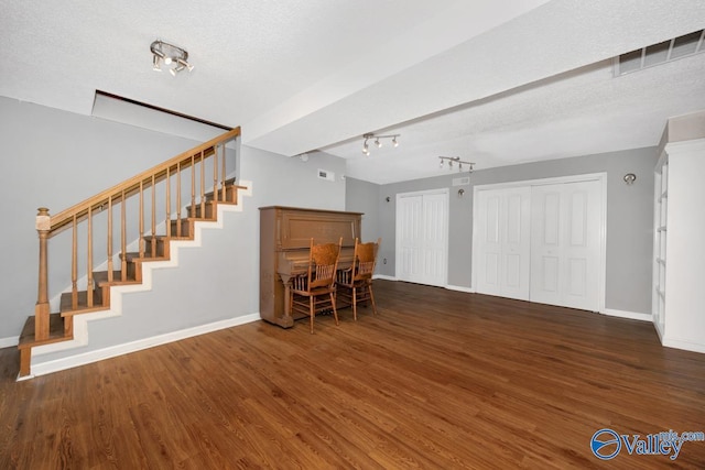 living area featuring wood finished floors, stairway, and baseboards