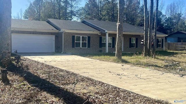 single story home featuring brick siding, roof with shingles, concrete driveway, fence, and a garage