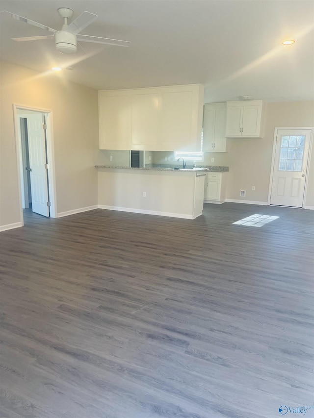 kitchen featuring a ceiling fan, dark wood-type flooring, open floor plan, white cabinetry, and a peninsula