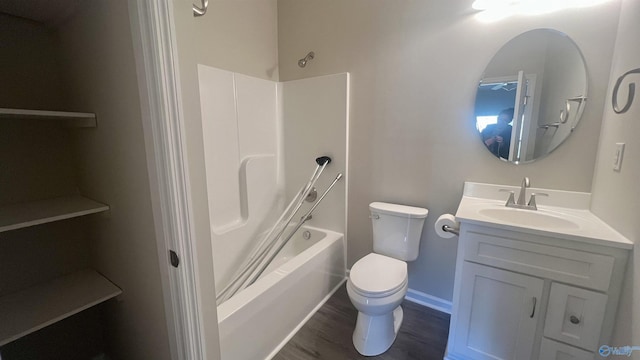 bathroom featuring toilet, wood finished floors, vanity, baseboards, and tub / shower combination