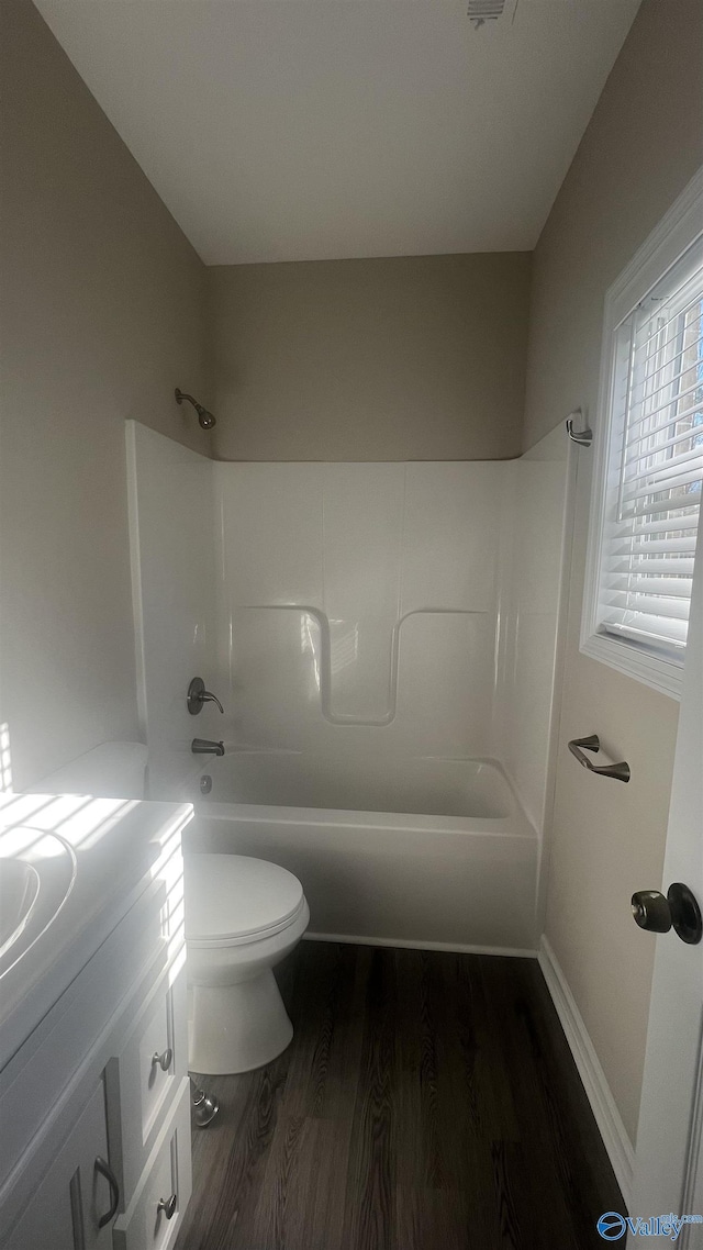 bathroom featuring  shower combination, vanity, toilet, and wood finished floors