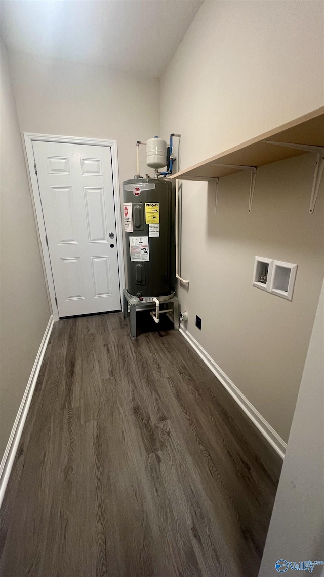 clothes washing area with dark wood-style floors, washer hookup, water heater, laundry area, and baseboards