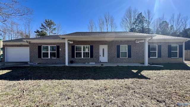 ranch-style home featuring a garage, roof with shingles, brick siding, and a front lawn