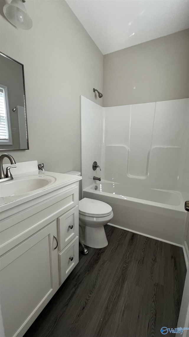 full bathroom featuring toilet, tub / shower combination, wood finished floors, and vanity