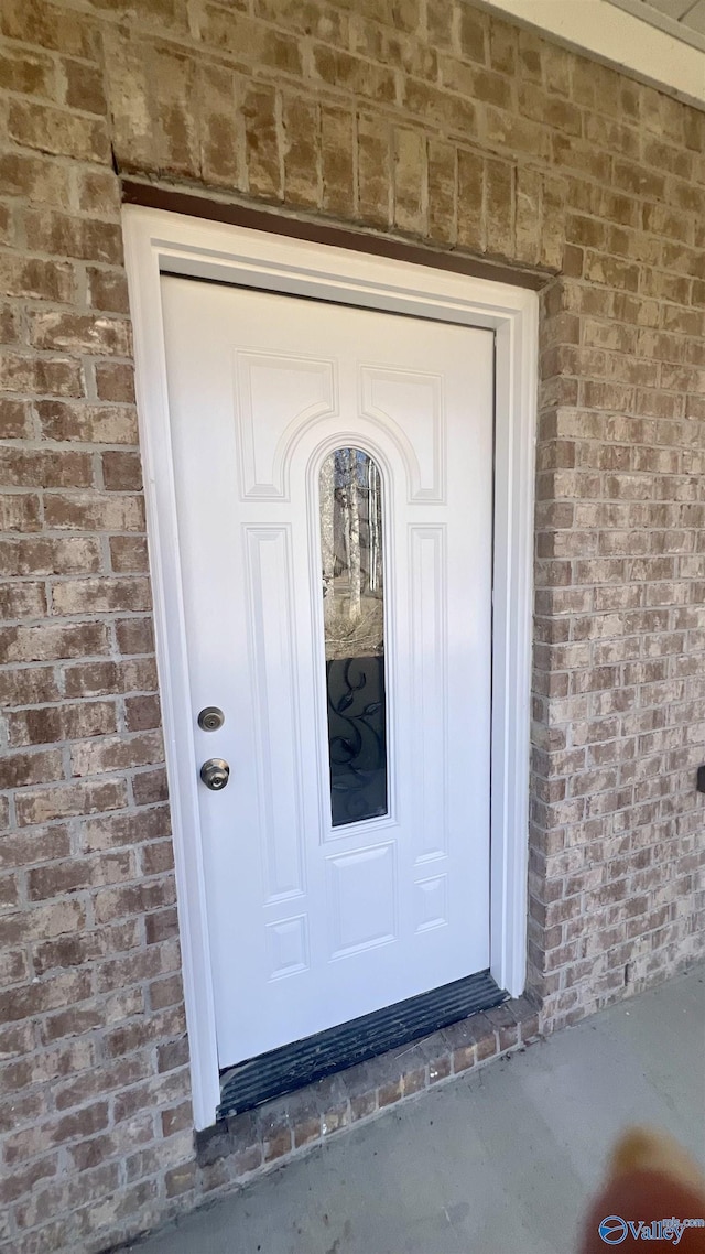 property entrance featuring brick siding