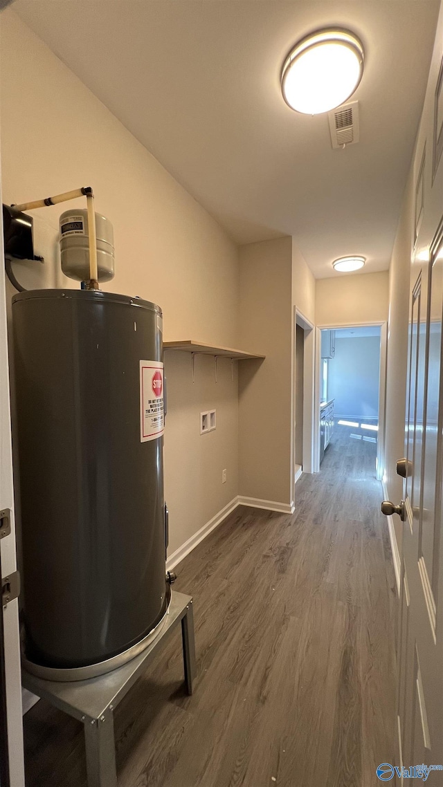 utility room featuring water heater and visible vents