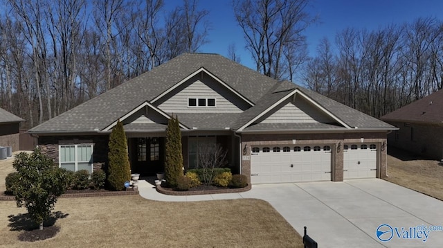 craftsman house with a garage, central air condition unit, and concrete driveway