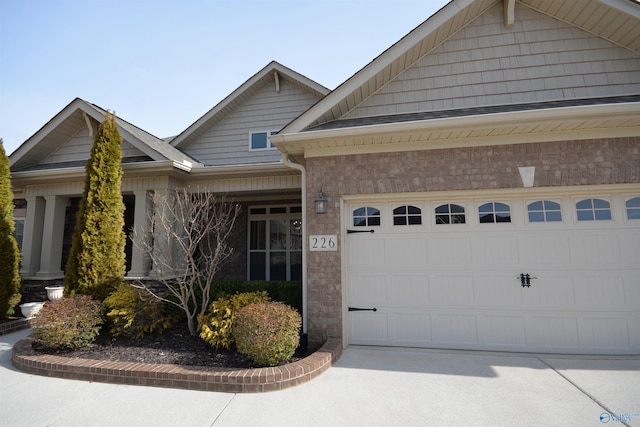 view of front of house featuring a garage, brick siding, and driveway