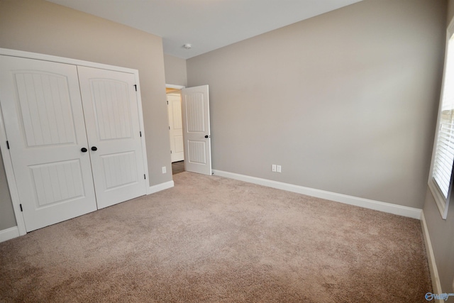 unfurnished bedroom with a closet, baseboards, and carpet floors