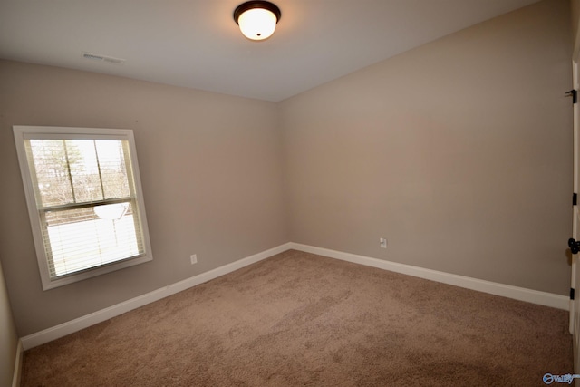 carpeted empty room with visible vents and baseboards