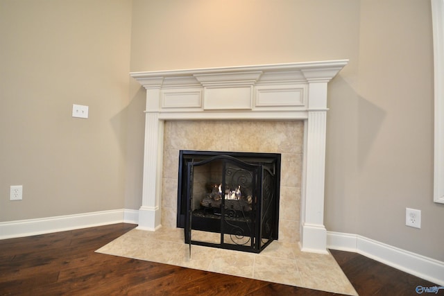 room details with wood finished floors, a fireplace, and baseboards