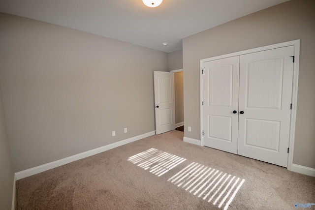 unfurnished bedroom featuring a closet, baseboards, and carpet floors