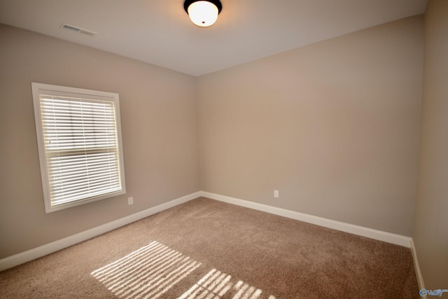 carpeted spare room with baseboards and visible vents