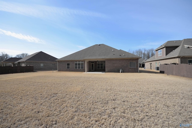 back of property with fence and brick siding