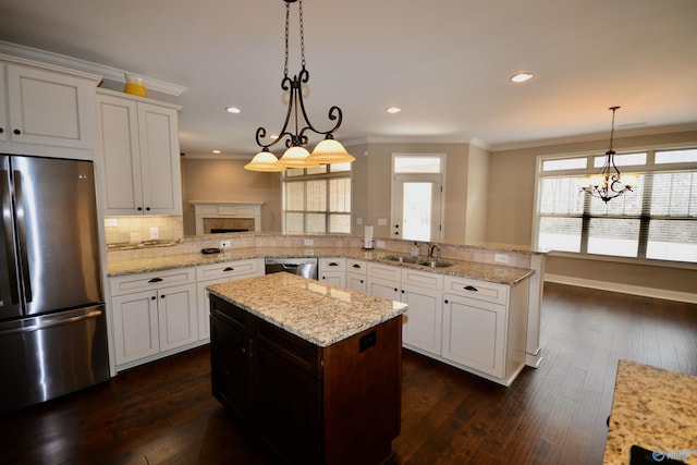 kitchen with dark wood-type flooring, ornamental molding, appliances with stainless steel finishes, and a sink