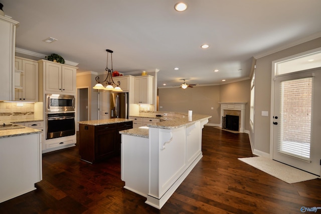 kitchen featuring a fireplace with flush hearth, backsplash, appliances with stainless steel finishes, and dark wood-style floors