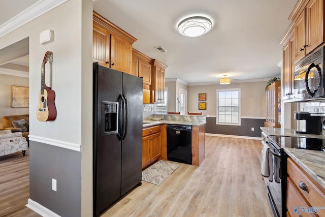 kitchen featuring crown molding, visible vents, open floor plan, a peninsula, and black appliances