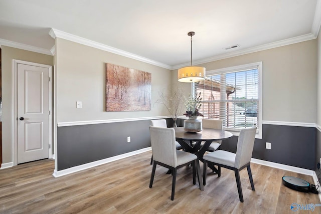 dining space featuring crown molding, visible vents, and wood finished floors