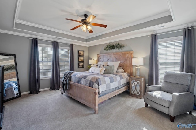 carpeted bedroom featuring a raised ceiling, crown molding, and baseboards