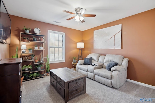 living room with light carpet, ceiling fan, visible vents, and baseboards