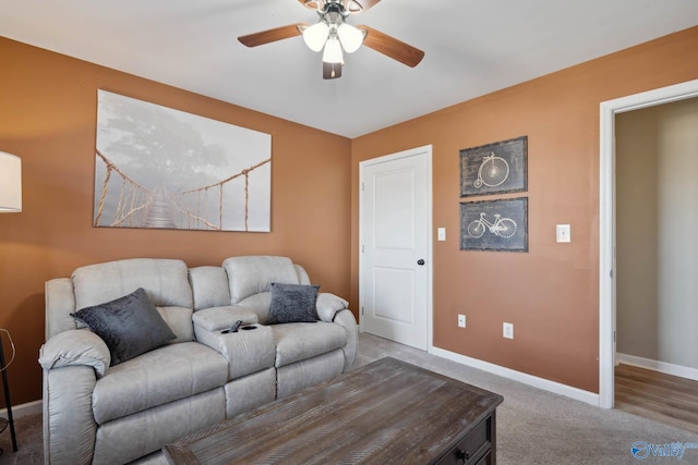 living room featuring a ceiling fan, carpet, and baseboards