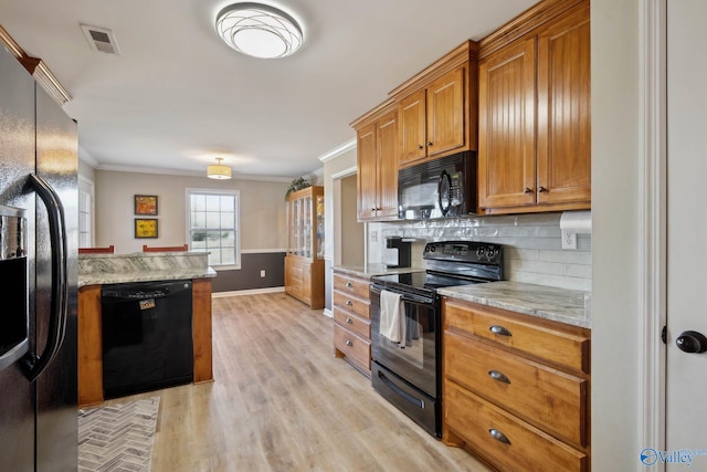 kitchen with brown cabinets, crown molding, visible vents, backsplash, and black appliances