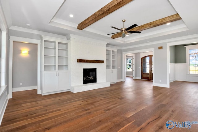 22938 Gunner Cir, Athens, AL 35613 - unfurnished living room featuring dark wood-style floors, a raised ceiling, ornamental molding, built in features, and a ceiling fan
