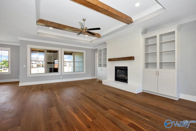 22938 Gunner Cir, Athens, AL 35613 - unfurnished living room featuring ornamental molding, a brick fireplace, ceiling fan, dark wood-style floors, and a raised ceiling