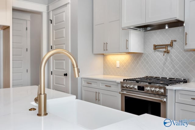 22938 Gunner Cir, Athens, AL 35613 - kitchen featuring high end stove, backsplash, a sink, under cabinet range hood, and white cabinets