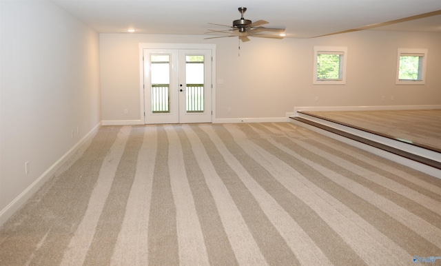 empty room featuring ceiling fan, light carpet, and french doors