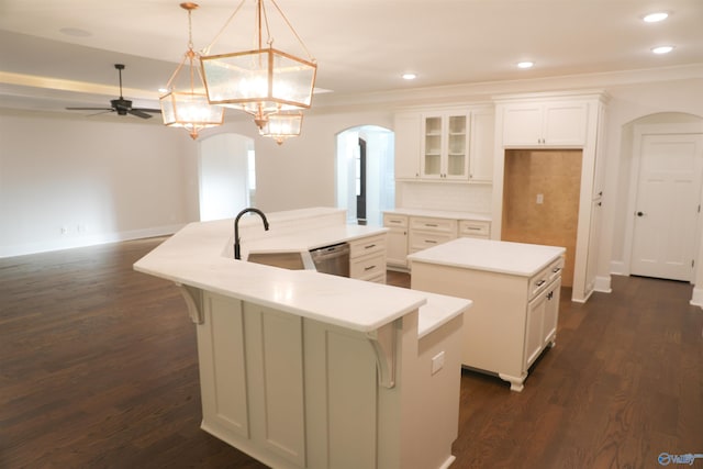 kitchen with dark wood-type flooring, ceiling fan, tasteful backsplash, and a kitchen island